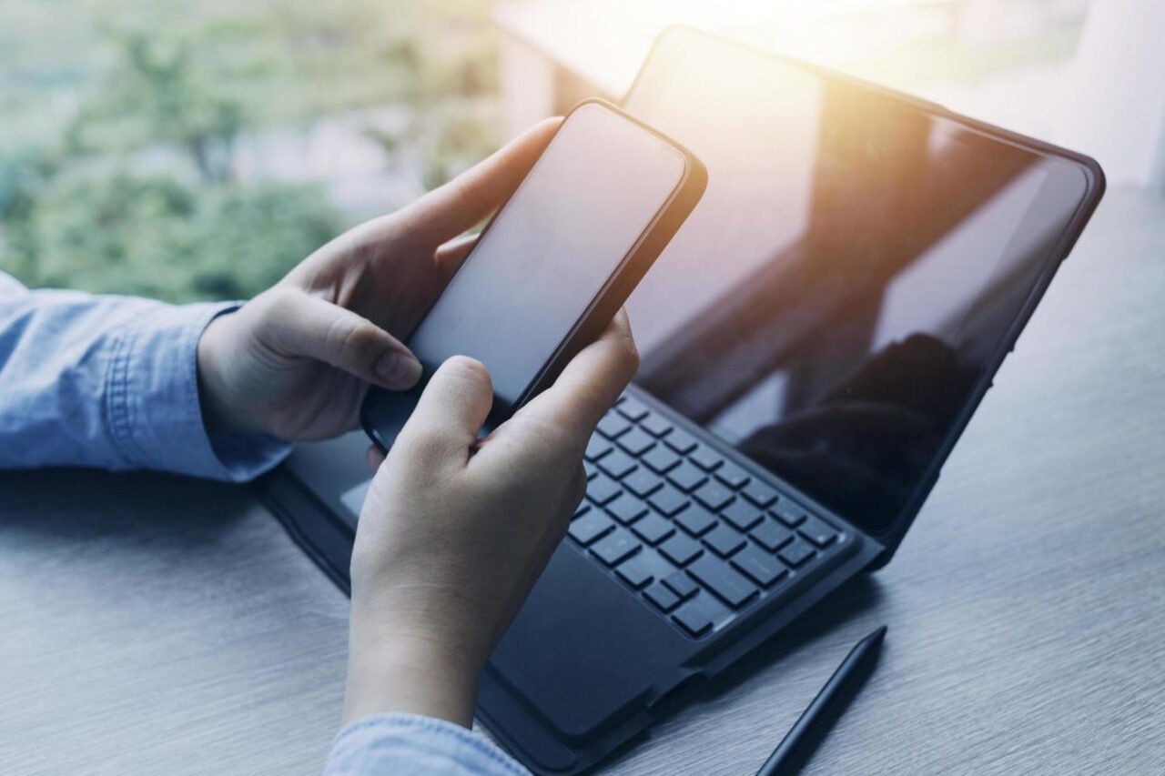 A person working on cellphone and laptop